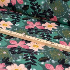 Molleton doux en coton à imprimé fleuri sur vert, tissu avec mètre pliant posé