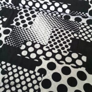 Viskosedruck mit Punktepatchwork in Schwarz und Weiss, flach liegende Ware